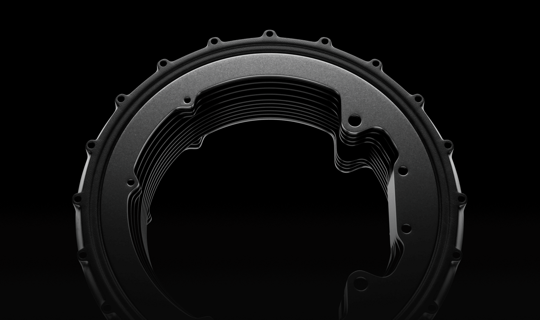 A black, metallic circular component with a layered structure against a dark background. The piece has a series of bolt-like protrusions along the outer edge and a smooth, reflective surface.